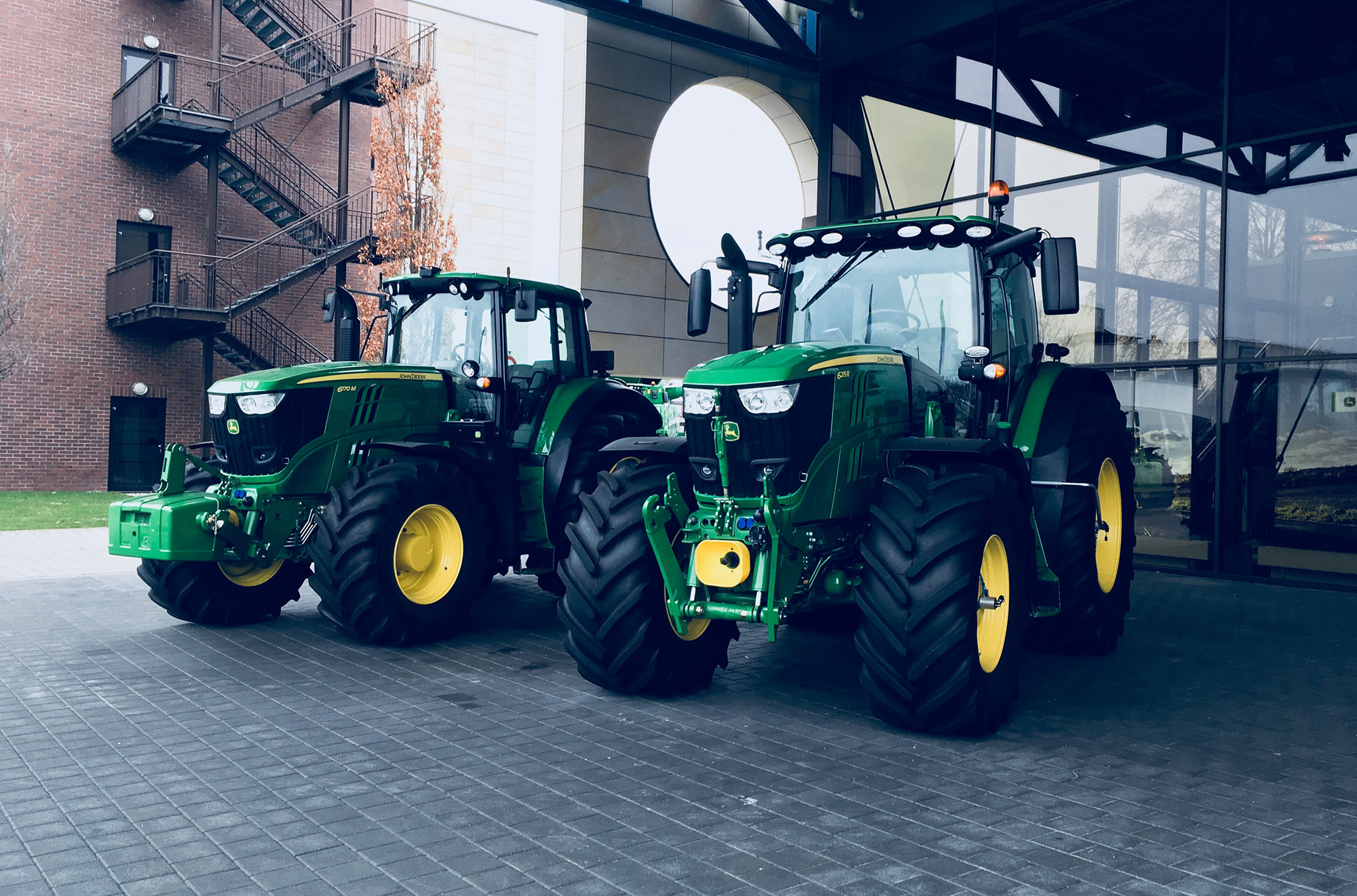 Zwei Traktoren vor dem John Deere Forum in Mannheim.