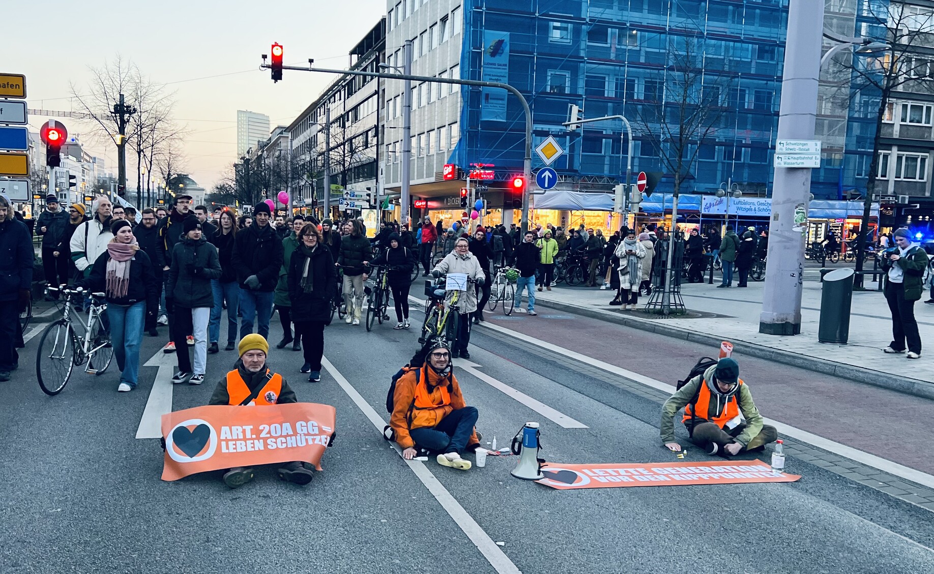 Protestierende der Letzten Generation sitzen auf der Straße. 