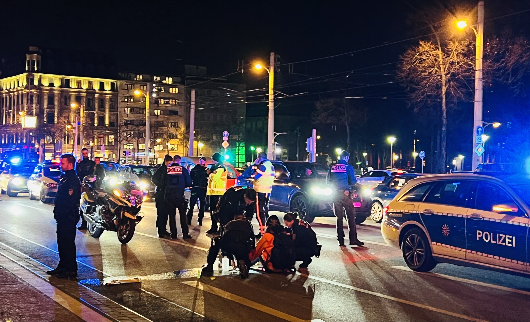 Nacht. Gesperrte Straße. Polizei versucht Protestierenden der Letzten Generation zu entkleben. 